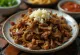 Carne Seca pasniegta ar rīsiem un svaigu koriandru